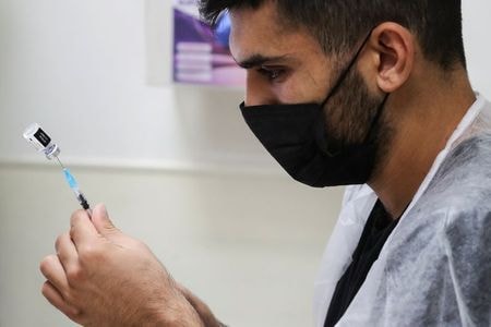 ８月２２日、 イスラエル保健省は新型コロナウイルスワクチンの３回目接種を行うと、６０歳以上の人の感染予防効果や重症化と入院を防ぐ効果が著しく高まることを示す試験データを公表した。エルサレムのワクチン接種会場で２０日撮影（２０２１年　ロイター/Ammar Awad）