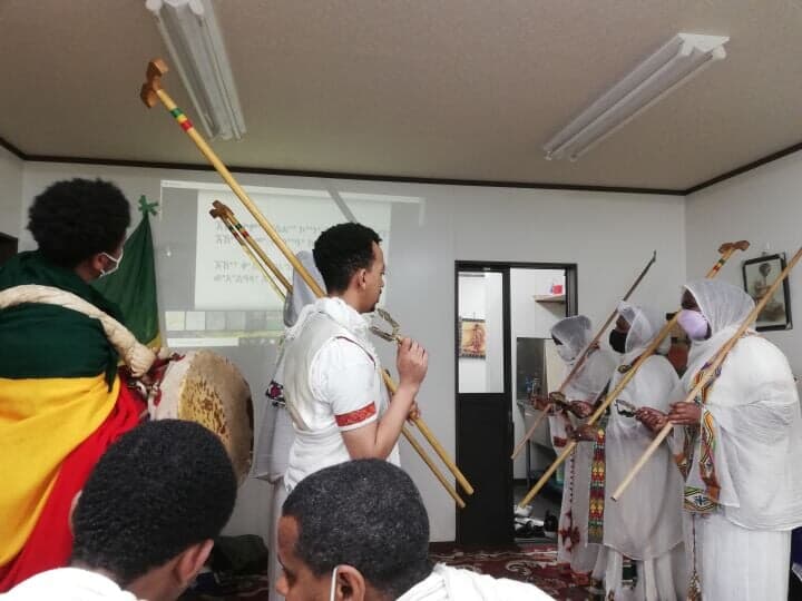 杖とツェナツル 太鼓をもって讃美歌を歌う