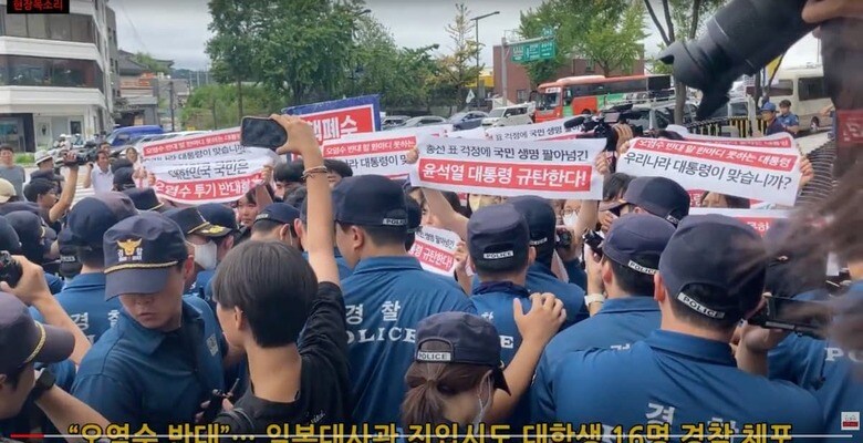 日本大使館前で「汚染水反対」とのバナーを掲げて抗議する学生たち　뉴스클레임 / YouTube