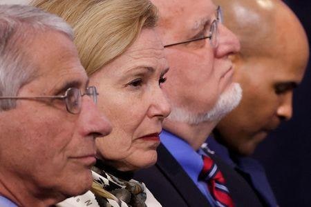 米ホワイトハウス内部で、新型コロナウイルス感染の大流行への対処方法を巡る意見の相違が、内輪もめと緊張に拍車を掛けている。写真は国立アレルギー研究所のファウチ所長（左）、新型コロナ対策チームのバークス調整官（左から２番目）。ホワイトハウスで４月２２日撮影（２０２０年　ロイター/Jonathan Ernst）