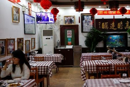 　１２月２日、トランプ米政権は、中国共産党の党員およびその家族による米国への渡航を制限する新たな規制を導入した。北京のレストラン、テレビでは米大統領選の様子が報じられている。１１月撮影（２０２０年　ロイター／Tingshu Wang）