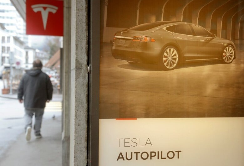 ５月２３日、米消費者団体は、電気自動車大手テスラの運転支援機能「オートパイロット」について、名称が「詐欺的で誤解を招く」として連邦取引委員会（ＦＴＣ）に調査を求めた。写真はチューリッヒにあるテスラのショールームに掲げられたオートパイロットの宣伝。３月撮影（２０１８年　ロイター／Arnd Wiegmann）
