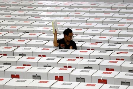 　４月１１日、インドネシアの高等裁判所は、２０２４年の大統領選挙と総選挙を２年延期するよう命じた下級審の判決について、司法権を逸脱しており、決定する権限がないとして破棄した。写真はジャカルタで投票箱を準備する作業員。２０１９年撮影（２０２３年　ロイター/Willy Kurniawan）