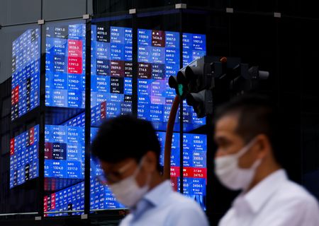 　８月２１日、午前の東京株式市場で日経平均は、前営業日比２５７円５７銭安の３万７８０５円３５銭と反落した。写真は株価スクリーンのそばを歩く人々。都内で２０２２年６月撮影（２０２４　ロイター／Issei Kato）