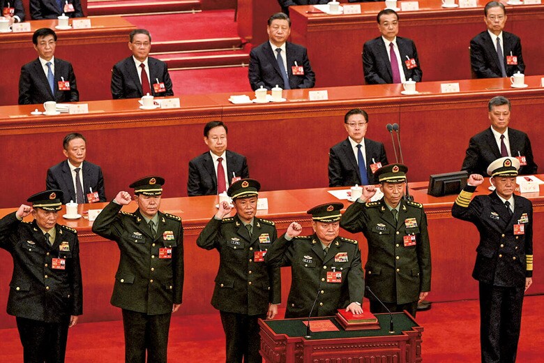 2023年3月の全国人民代表大会全体会議で、習近平（最後列左から3人目）が見守るなか、憲法宣誓を行う党中央軍事委員会の新メンバー6人。今回、張又侠副主席（壇上）と劉振立軍統合参謀部参謀長（最前列左から2人目）が粛清され、残るは張昇民副主席（同一番左）だけになった　GREG BAKERｰPOOLｰREUTERS