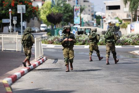 １０月１１日、 米軍制服組トップのブラウン統合参謀本部議長は、パレスチナ自治区ガザを実効支配するイスラム組織ハマスによるイスラエル攻撃を受け、同国に敵対的な他の勢力が攻撃を準備している兆候は現時点で確認していないと述べた。写真は同日、イスラエル南部スデロットの町をパトロールするイスラエル兵（２０２３年　ロイター/Violeta Santos Moura）