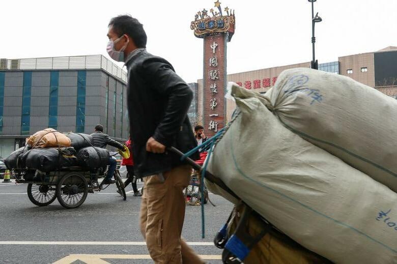 中国国家衛生健康委員会の3日の発表によると、中国本土で2日に新たに確認された新型コロナウイルスの感染者は125人と、前日の202人から減少し、当局が1月に集計結果の公表を開始して以降で最小となった。写真は浙江省杭州で、マスクをして荷物を運ぶ男性、1日撮影。China Daily via REUTERS（2020年　ロイター）