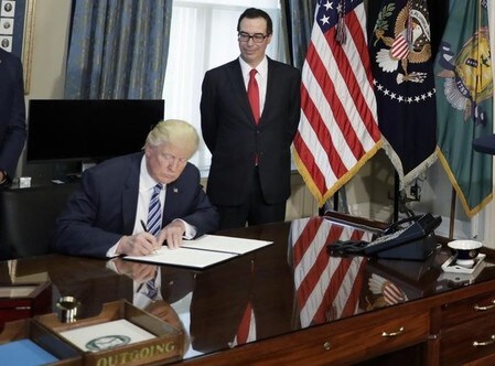 　５月２５日、トランプ米政権が議会に今週提出した予算教書では、例年同時に公表される「グリーンブック（歳入関連提案）」がなくなっていた。写真はトランプ米大統領（左）とムニューシン米財務長官（右）。ワシントンで４月撮影（２０１７年　ロイター／Kevin Lamarque）