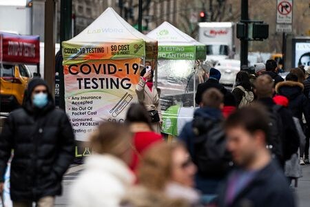 米厚生省は２０日、新型コロナウイルスの派生型の検出が可能な検査キットを全国の家庭に無料で配布すると発表した。写真はコロナウイルス感染症の検査会場近くを歩く人々。ニューヨークで２２年１２月撮影。（2023年 ロイター/Eduardo Munoz/File photo）