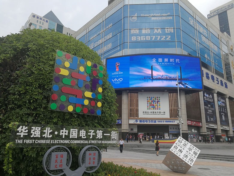 広東省深圳市の電子街「華強北」。中国一の電気街を意味する「中国電子第一街」と書かれた看板がある。その横の立方体には「公正、平等、自由、法治」など社会主義的核心価値観が書かれている。写真提供：ニコ技深圳観察会