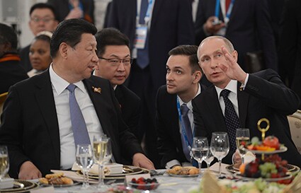 対独戦勝70周年記念式典で歓談する習近平とプーチン　Ria Novosti-REUTERS