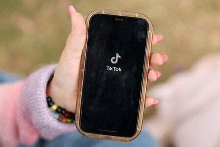 　３月１３日、業界データによると、オーストラリアで１６歳未満のソーシャルメディア（ＳＮＳ）利用が禁止されてから２か月が経過したが、依然として５人に１人がＳＮＳを利用しており、年齢制限手法の有効性が疑問視されている。写真は、携帯電話でＴｉｋＴｏｋアプリを開く少女。２０２５年１１月撮影（２０２６年　ロイター/Hollie Adams）