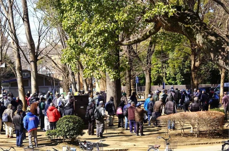 公園で炊き出しを待っている貧困者たち。3分の1程度はホームレスだろうか