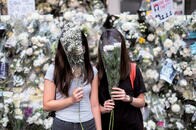 【デモ隊の告白9】「警察を調査しないと、みんなの気が済まない」駅で花を供える女性