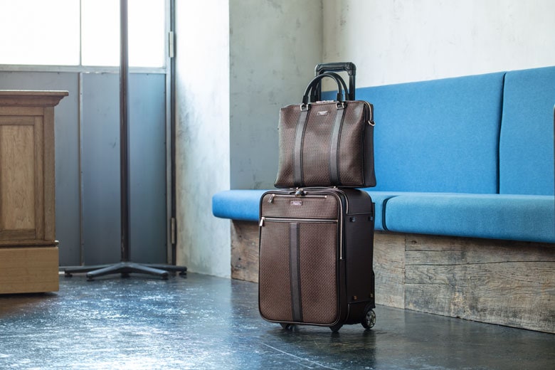 PVC素材で合わせた、セット使いがおすすめの薄マチタイプの2Roomブリーフバッグ／￥107,000（税別）／サイズ：H28.5×W40×D7cmと、トロリー／￥210,000（税別）／サイズ：W45×W35×D21cm。軽快で丈夫、機能性にも優れているためビジネスの出張のみならず旅にも重宝する