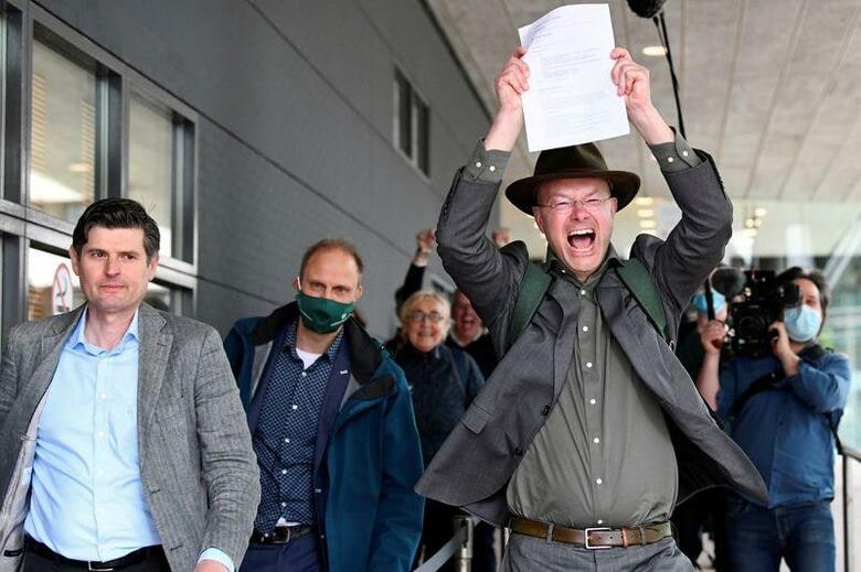 オランダ・ハーグの裁判所は26日、英蘭系石油大手ロイヤル・ダッチ・シェルの現行の温暖化ガス削減目標は十分でないとし、2030年までに19年比で45％削減するよう命じる判決を言い渡した。法律専門家や環境団体は画期的な判決だと評価した。写真は、判決を喜ぶ「地球の友」オランダ支部の関係者ら（2021年　ロイター/Piroschka van de Wouw）