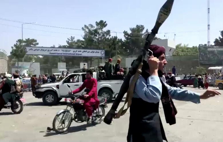 カブール空港の外で群衆を追いかけるタリバン戦闘員（8月16日）　REUTERS TV/via REUTERS