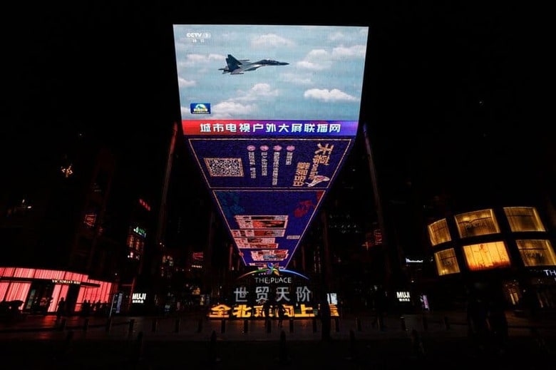 4月9日、中国軍は、台湾周辺で2日目となる軍事演習を行い、台湾に対する正確な攻撃のシミュレーションを実施した。写真は8日、北京のショッピング街のモニターに表示されるニュース映像（2023年　ロイター/Tingshu Wang）