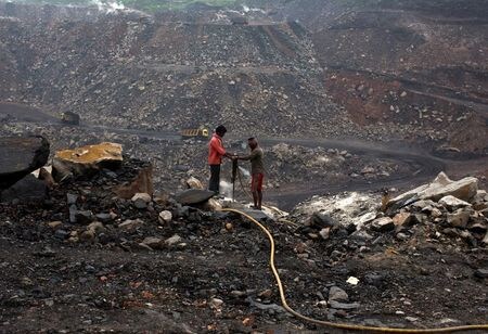 　国連気候変動枠組み条約第２６回締約国会議（ＣＯＰ２６）のアロック・シャルマ議長は１１月１４日、中国とインドは同会議で石炭火力に関する文言修正を推進した理由について途上国への説明が必要になると指摘した。写真は インド東部ジャールカンド州ダンバード地区の露天掘り炭田で掘削する労働者ら、２０１２年９月撮影（２０２１年　ロイター/Ahmad Masood）