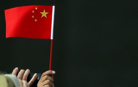 　１０月２３日、中国人民銀が政策金利と銀行の預金準備率を引き下げた。写真は中国国旗を持つ人。９月撮影（２０１５年　ロイター／Tony Gentile）