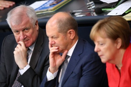 　７月５日、ドイツ連立政権を構成する３政党は、欧州連合（ＥＵ）の他の加盟国で保護申請した難民がドイツに流入した場合の対応策について、合意に達した。写真は予算審議会に出席するメルケル首相(右)、ショルツ財務相(中央）とゼーホーファー内相(左）。４日にベルリンで撮影(２０１８年　ロイター／HANNIBAL HANSCHKE)