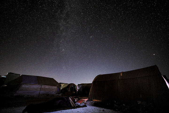 シリア北西部イドリブ県マーラトミスリンの避難民キャンプでテントの外で眠る男性（2020年7月）©OMAR HAJ KADOUR/AFP