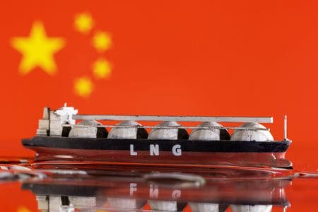 　２月２８日、仏トタルエナジーズの幹部は、世界の液化天然ガス（ＬＮＧ）需要が２０２４年に拡大するとの見通しを示した。写真は中国の国旗とＬＮＧタンカーの模型。２０２２年５月撮影（２０２４年　ロイター/Dado Ruvic）