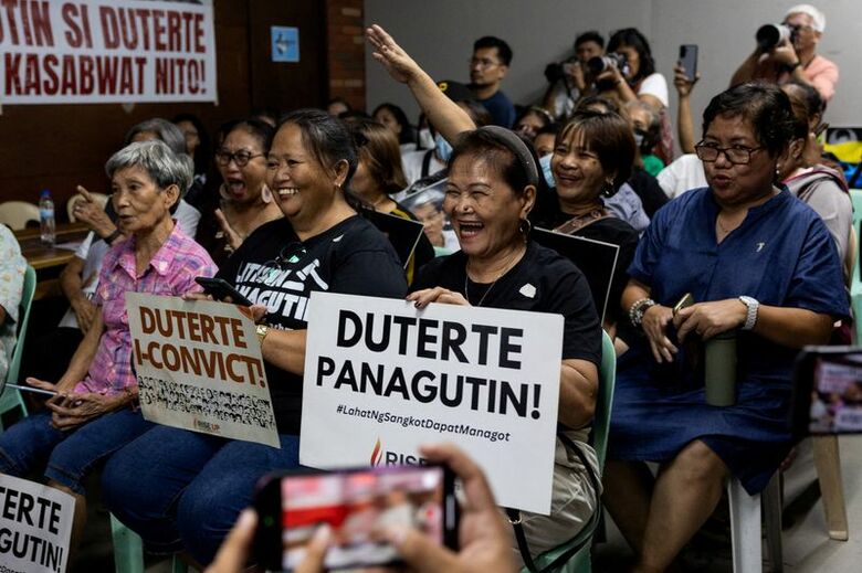 フィリピンのドゥテルテ前大統領が国際刑事裁判所（ICC）に出廷する様子を視聴する人々。9月16日撮影。REUTERS/Eloisa Lopez