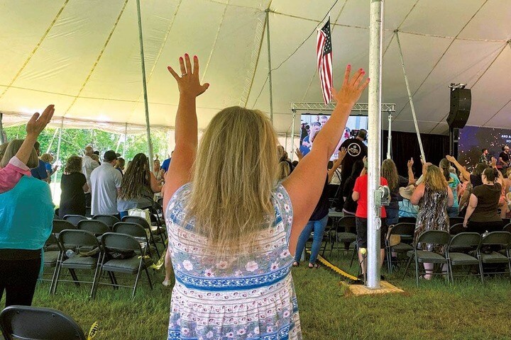 新カリスマ運動の集会で指導者たちの話に耳を傾ける福音派の信者ら
