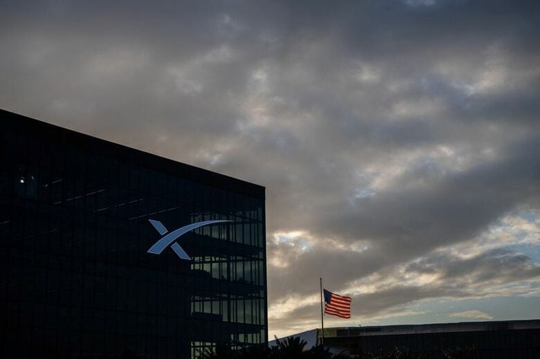 写真は米テキサス州スターベースにあるスペースXのオフィスビルと米国国旗。4月21日撮影。REUTERS/Carlos Barria