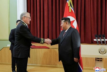 北朝鮮は、ロシアに対しウクライナの重要な民間インフラへのミサイル攻撃の強化支援を行い、２万個以上の軍需品コンテナや、９００万発の砲弾およびロケット砲弾薬を供給したもよう。写真は金正恩朝鮮労働党総書記と握手を交わすマツェゴラ駐北朝鮮ロシア大使。９日撮影の提供写真。（２０２５年　ロイター/Korean Central News Agency. KCNA via REUTERS）