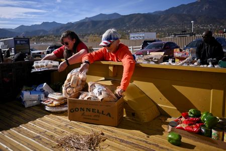 写真はトラックの荷台に食料を積むボランティアら。11月7日、米コロラド州コロラドスプリングスの食料配給所近くで撮影。REUTERS/Mark Makela