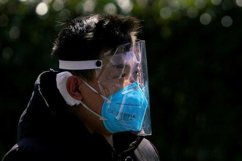 中国の保健当局者らによると、中国本土での新型コロナウイルスによる肺炎は、新たな感染者の数が1月30日以来初めて2000人を割り込んだ。写真は17日、上海で街を歩く男性（2020年　ロイター/Aly Song）