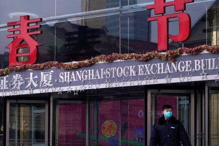 中国の上海証券取引所と深セン証券取引所は７日、高頻度取引業者に追加の取引手数料を課すルール案を公表した。中国・上海の浦東金融街にある上海証券取引所ビルに立つ警備員で2020年2月に撮影（２０２４年　ロイター／Aly Song）