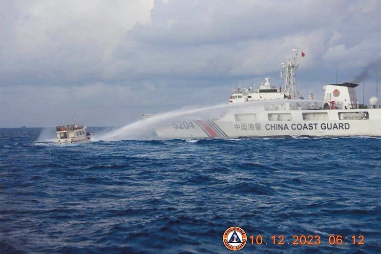 フィリピンの補給船（左）に放水を浴びせる中国海警局の艦艇（23年12月）　PHILIPPINE COAST GUARDｰHANDOUTｰREUTERS