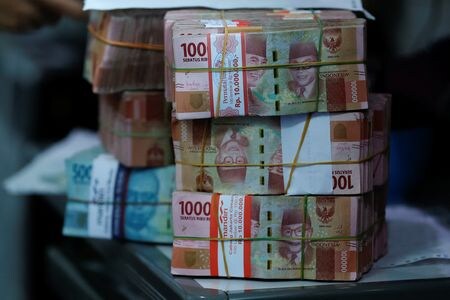 　８月２９日、インドネシア中央銀行は、ルピアの安定のために外国為替市場で積極的な介入を継続する方針を示した。写真は、両替商のインドネシアルピア紙幣。ジャカルタで２０２２年１０月撮影（２０２５年　ロイター/Willy Kurniawan）