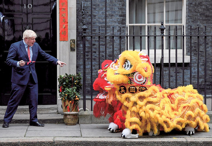 首相官邸前で春節を祝う神獣を歓迎するジョンソン（20年1月24日）　TOBY MELVILLE-REUTERS