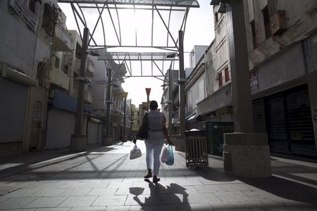 ８月３日、米自治領プエルトリコが、１日に期限を迎えた債務の返済ができず、デフォルト（債務不履行）となった。シャッター街を歩く女性、サンフアンで先月撮影（２０１５年　ロイター／Alvin Baez）