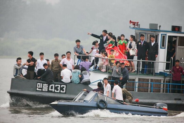 ９月１３日、北朝鮮経済は、中国による燃料輸出削減など、貿易面での締め付けによる打撃を受けつつある兆候を見せている。写真は９日、中朝国境の鴨緑江で船に乗る北朝鮮の人々。中国丹東から撮影（２０１７年　ロイター/Jacky Chen）