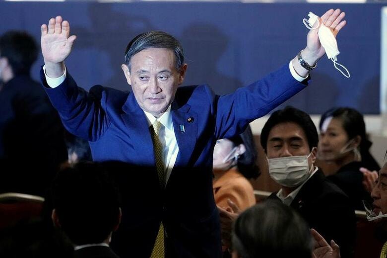 自民党の新総裁に当選した菅義偉官房長官は、１６日に新首相として新たな政権を発足させる。山積する課題の対応の行方を左右するのは、組閣と党役員人事、衆院解散の時期などになりそうだ。写真は新総裁に選ばれ、両手を挙げてポーズを取る菅氏。2020年9月14日、代表撮影（2020年　ロイター）