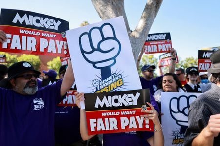 　７月２４日、米カリフォルニア州のディズニーランド・リゾート従業員１万４０００人を代表する労働組合は、米娯楽・メディア大手ウォルト・ディズニーと新たな労働協約について暫定合意したと発表した。写真は公正な賃金を求める働組合とディズニーのキャストメンバー達。米カリフォルニア州 で１７日撮影（２０２４　ロイター／David Swanson）