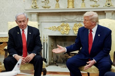 トランプ米大統領（写真右）は先週の中東歴訪の際、サシリアのシャラア暫定大統領と会談し「彼には可能性がある。真のリーダーだ」と持ち上げた。イスラエルのネタニヤフ首相（左）の孤立をこれほどくっきりと映し出す光景はこれまでなかった。４月７日、ワシントンで撮影（２０２５年　ロイター/Kevin Mohatt）