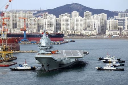 １２月１７日、中国国営メディアによると、中国初の国産空母「山東」が、海軍に引き渡され、就役した。写真は２０１８年１２月、大連の港を出る中国初の国産空母（２０１９年　ロイター）