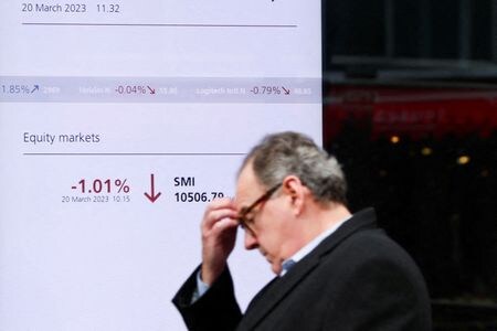 ３月２４日、バーゼル銀行監督委員会のパブロ・エルナンデス・デ・コス議長（スペイン中央銀行総裁）は、システム上で重要ないわゆる「影の銀行」が金融安定を脅かす可能性について監視を強化していく考えを示した。写真はスイスの市場インデックスを示すボードの前を歩く人。チューリヒで２０日撮影（２０２３年　ロイター/Denis Balibouse）