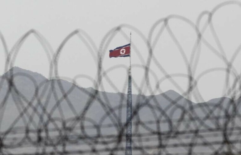 １０月２７日、韓国統一省の白泰鉉（ペク・テヒョン）報道官は、北朝鮮が拿捕（だほ）した韓国漁船と船員が同日中に引き渡されると明らかにした。写真は南北朝鮮国境近くの北朝鮮側ではためく北朝鮮の旗。韓国側から２０１２年３月撮影（２０１７年　ロイター／Yuriko Nakao）