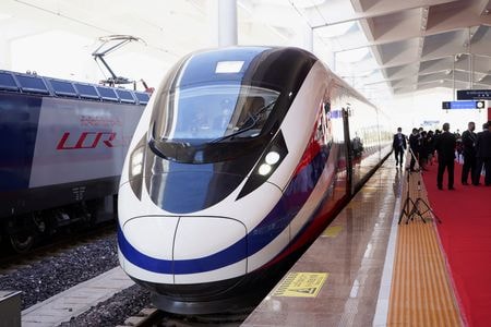 　１月２９日、タイ政府は、ラオスを経由して中国と結ぶ高速鉄道の距離６０９キロ区間について、当初の計画より１０年近く遅れて２０３０年に開通する予定だと発表した。写真は、ラオスのビエンチャンで開催された、中国南西部昆明とビエンチャンを結ぶ高速鉄道プロジェクトの引渡し式典で駅に待機する電車。２０２１年１２月撮影（２０２５年　ロイター/Phoonsab Thevongsa）