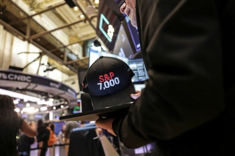 2025年7月30日、ニューヨーク証券取引所（NYSE）で、「S&P 7,700」と書かれたキャップ。REUTERS/Jeenah Moon