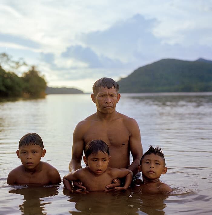 アマゾナス県の川で入浴する先住民族の家族。アマゾンの先住民族の暮らしは森林伐採や麻薬密売に脅かされている