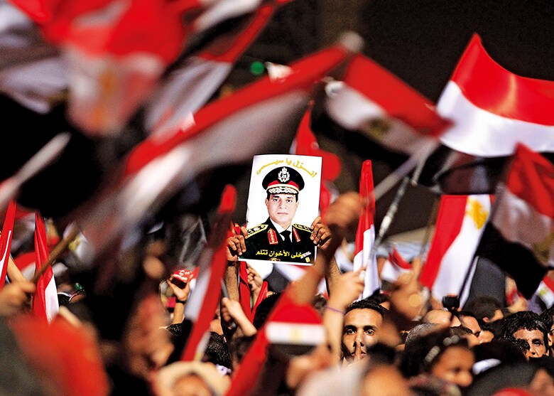 シシの肖像を掲げる反モルシ派のデモ参加者（13年7月）