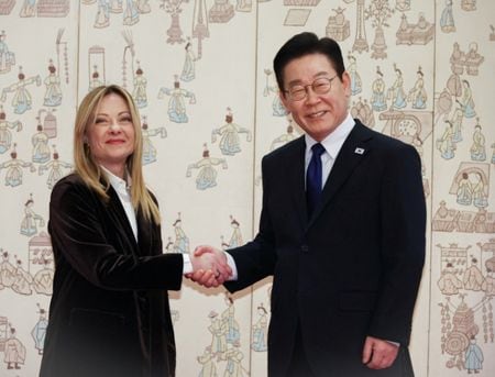 写真は握手するイタリアのメローニ首相と韓国の李在明大統領。１月１９日、ソウルで撮影。韓国の聯合ニュース提供。REUTERS